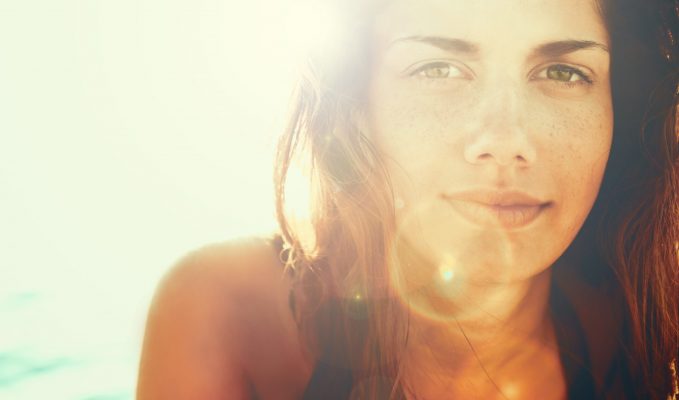 Face of young beautiful woman in summer sun